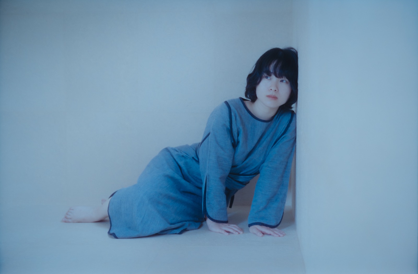 作品の掛かった部屋で、赤ん坊をあいだに笑う夫婦