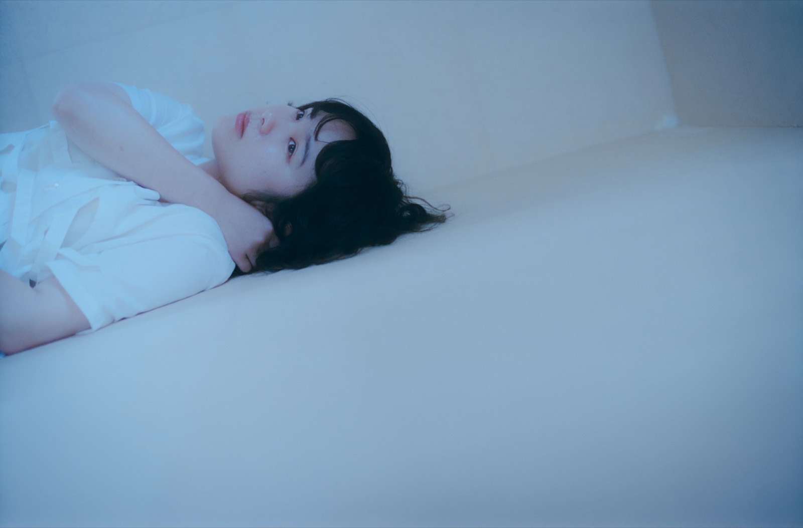 紅葉した木の下、縁側に洗濯物が干された古い家